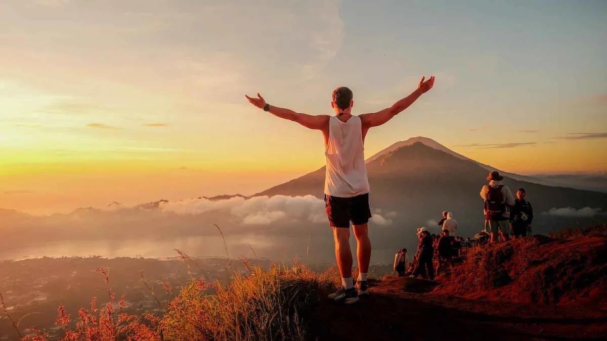 Small group climbing the ridge trail by head-torch on a Mount Batur sunrise hike tour before dawn, Bali